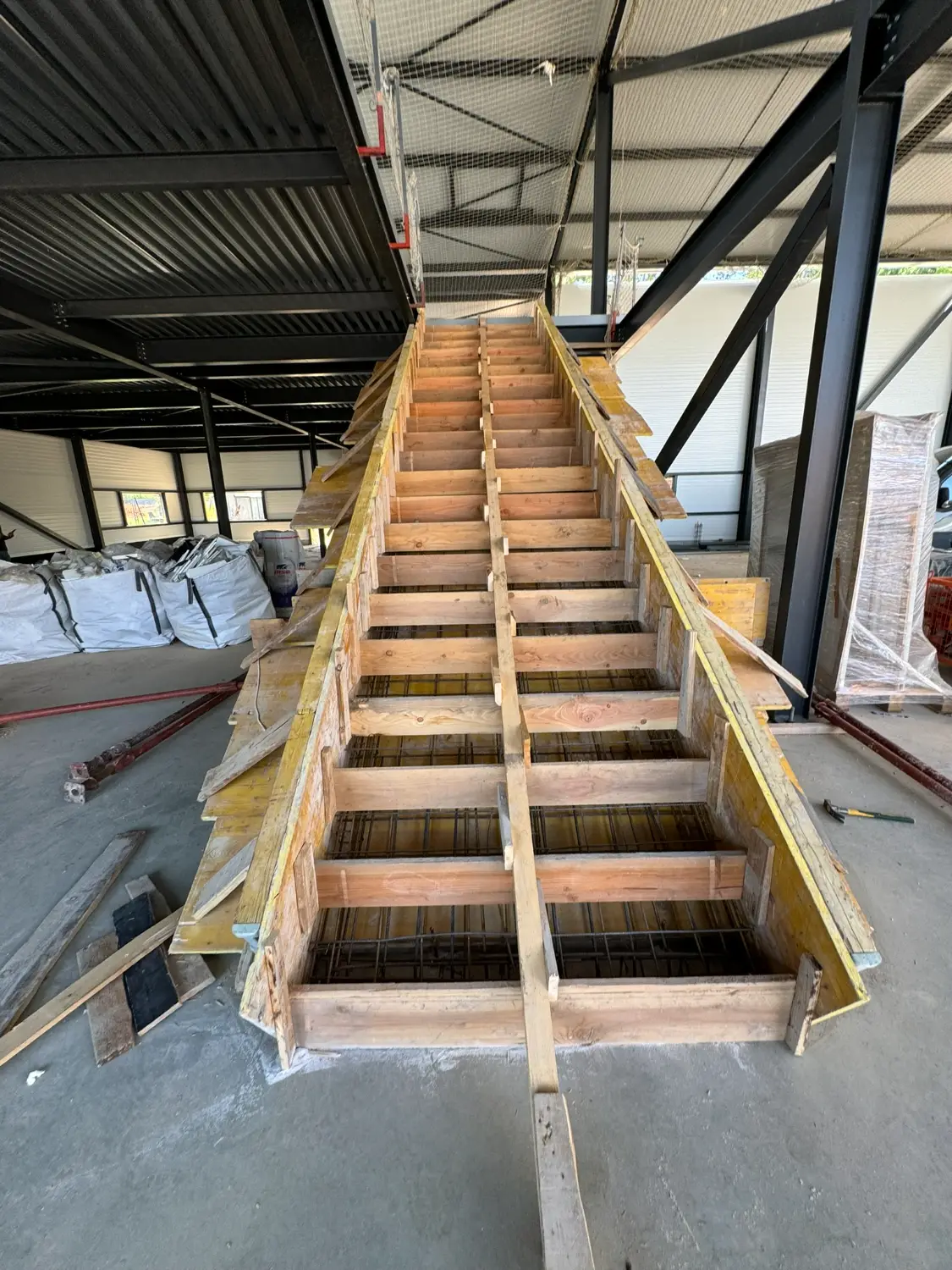 Coffrage bois de l'escalier béton armé en cours de réalisation, construction bureaux Bouc Bel Air 13 RSTS